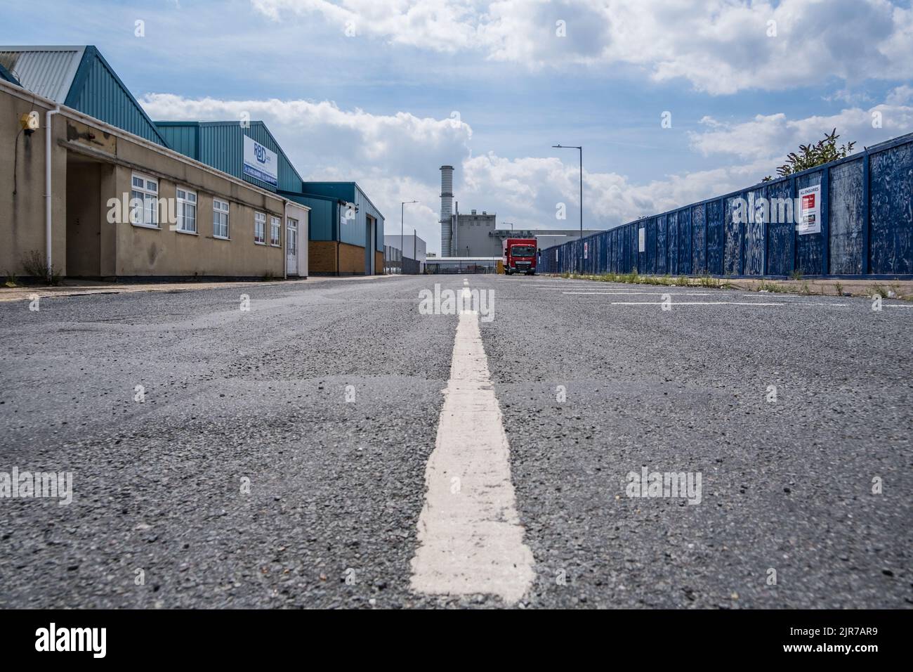 Perspective view along tarmac road in an industrial estate towards Great Yarmouth Power Station, Norfolk, England, UK. Stock Photo