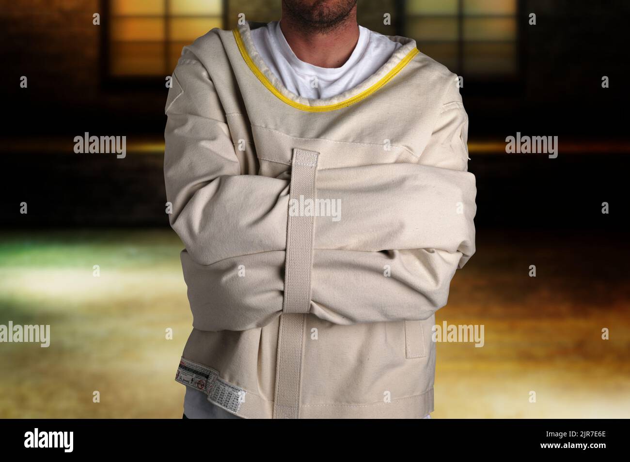 Man wearing a straitjacket, a symbol of despair due to mental illness Stock Photo