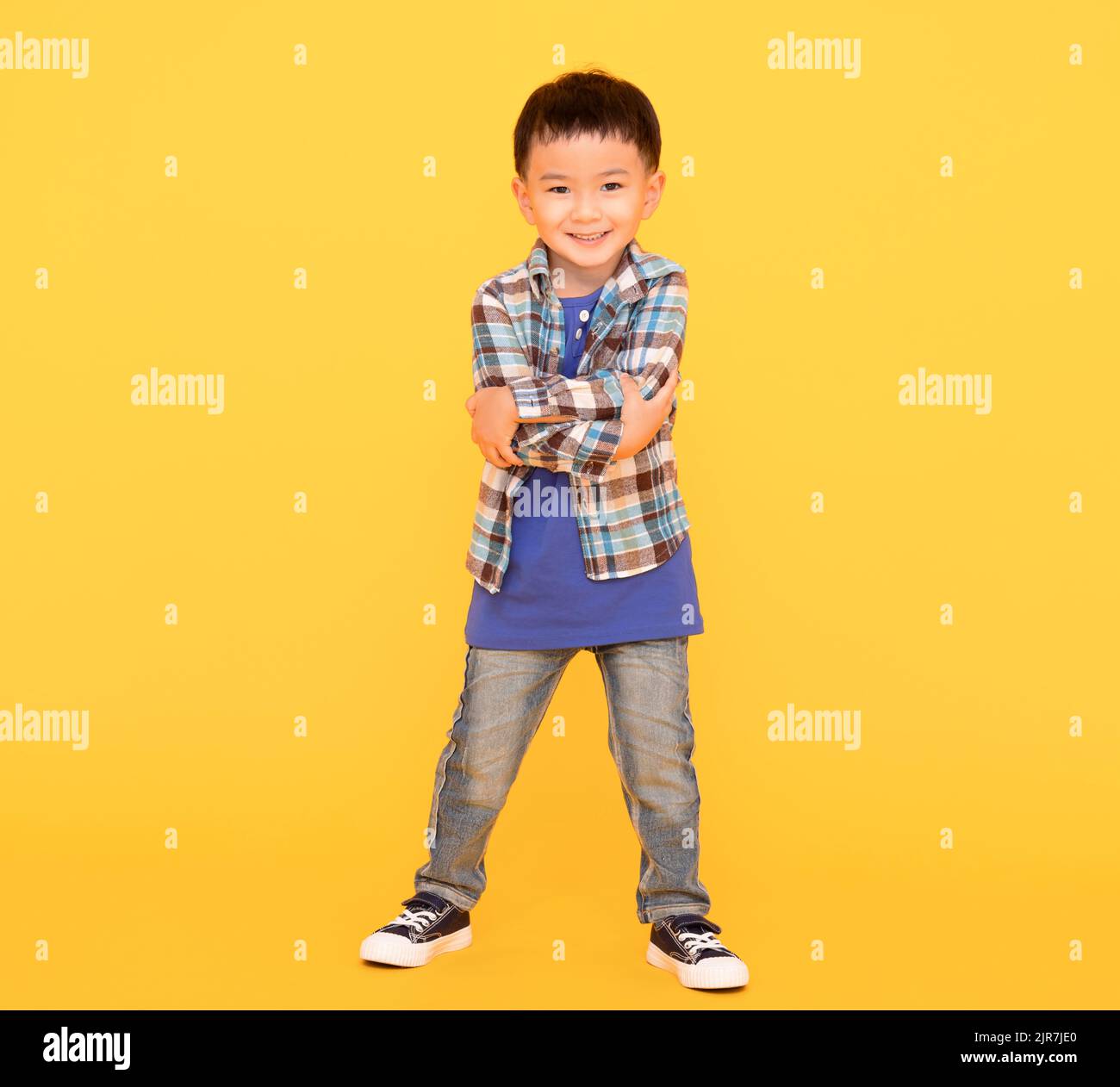 happy asian kid standing  over yellow background Stock Photo