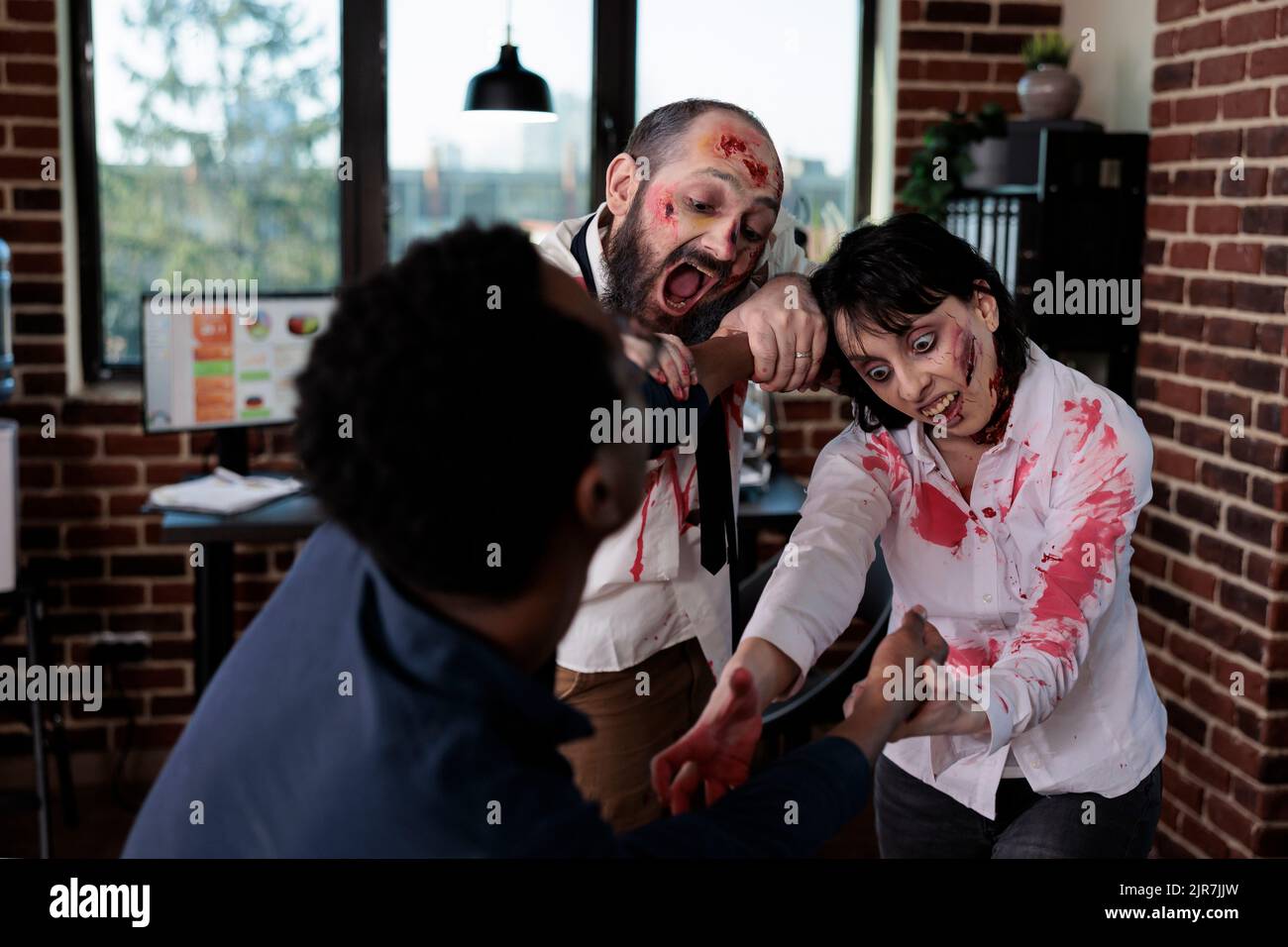 Creepy angry zombies chasing after businessman, frightened person running from brain eating bloodthirsty monsters. Scared man being afraid of undead aggressive corpses, walking dead. Stock Photo