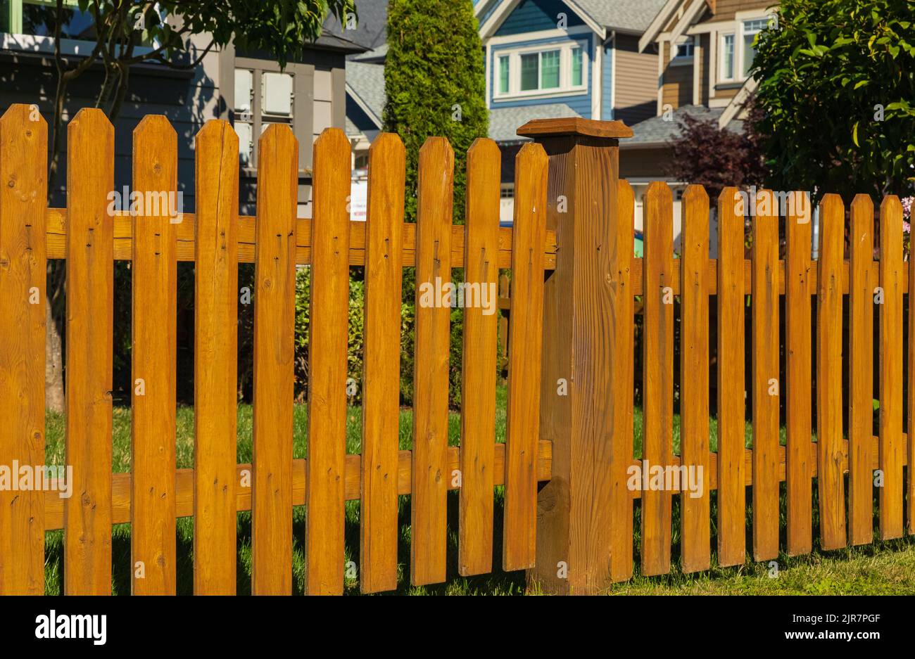 Nice wooden fence around house. Wooden fence with green lawn Stock