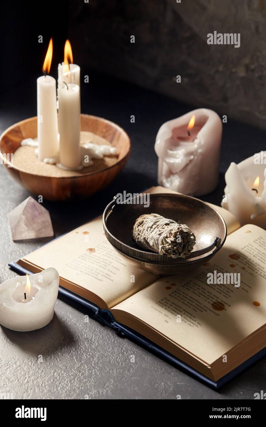 magic book, sage, burning candles and ritual staff Stock Photo Alamy