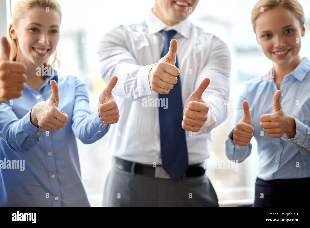 happy business team showing thumbs up at office Stock Photo - Alamy