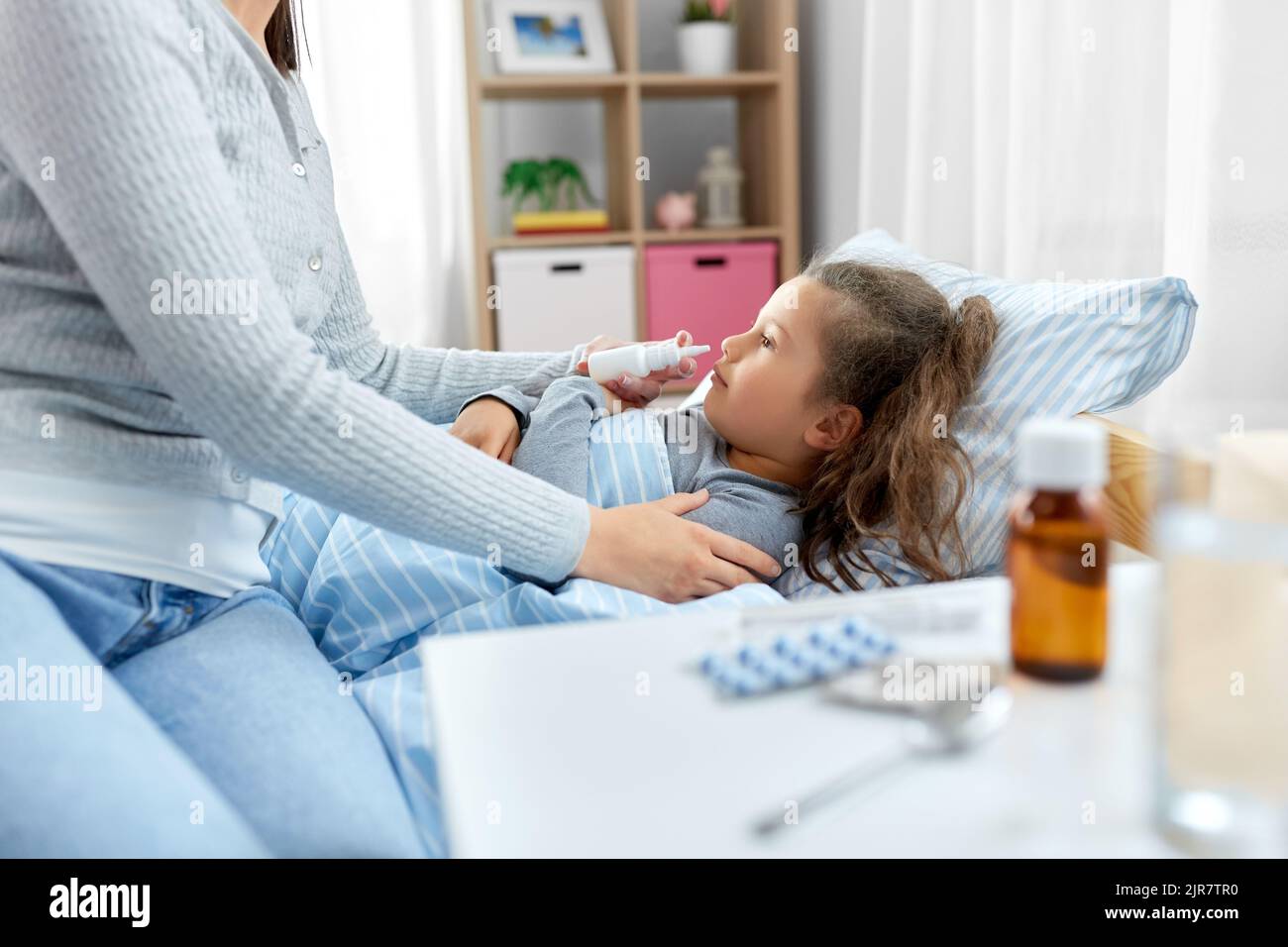 mother with nasal spray treats sick daughter Stock Photo Alamy