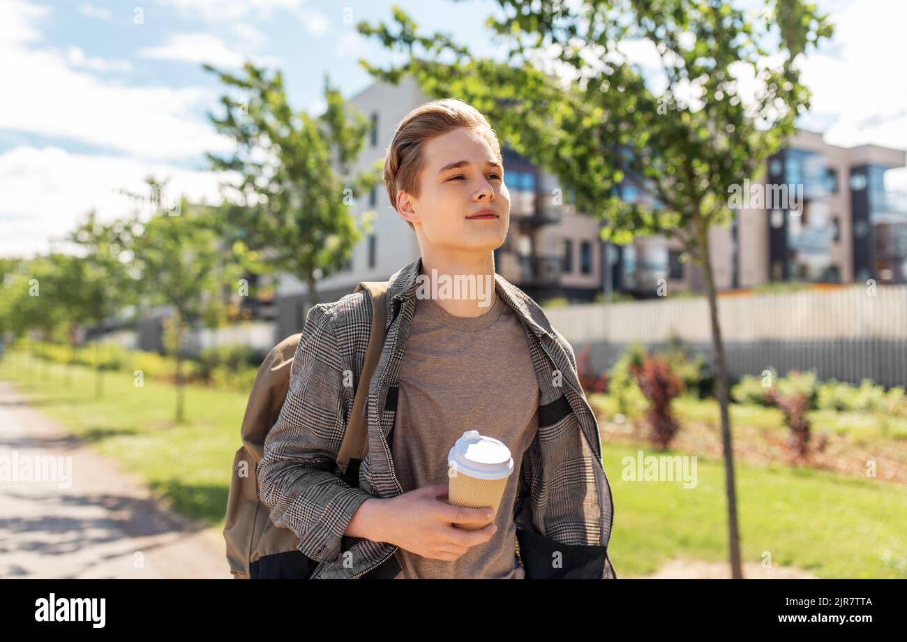young man with backpack drinking coffee in city Stock Photo