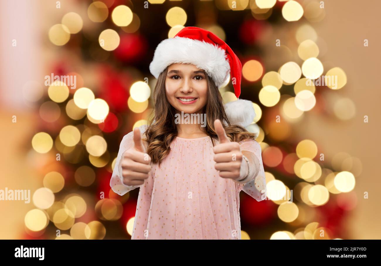 happy teenage girl showing thumbs up on christmas Stock Photo - Alamy