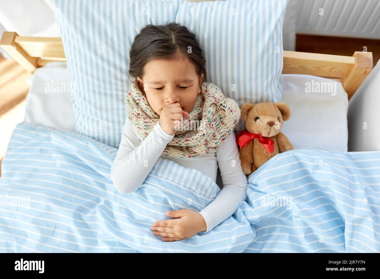 sick coughing girl lying in bed at home Stock Photo Alamy