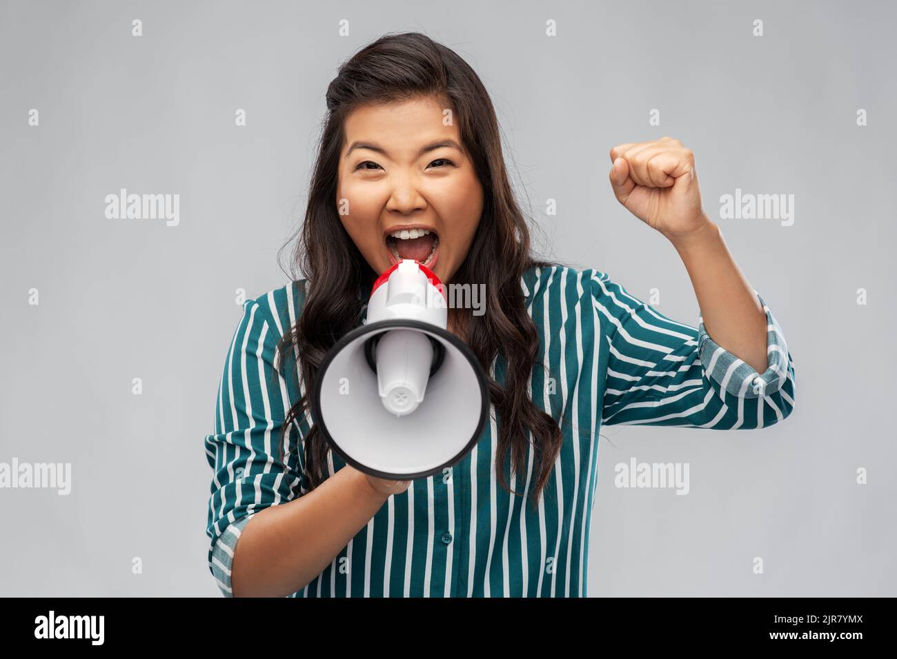 angry young asian woman speaking to megaphone Stock Photo