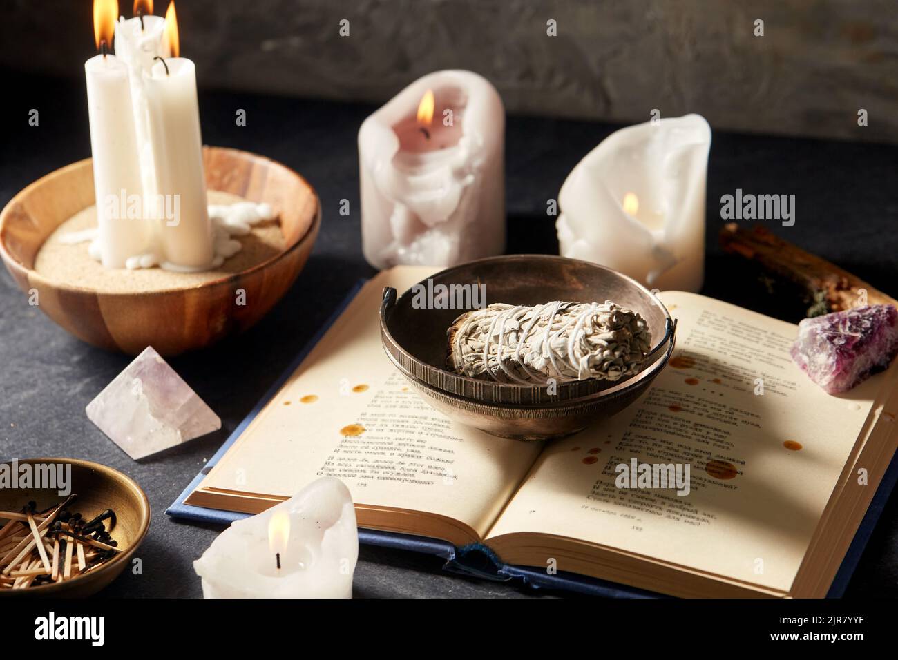 magic book, sage, burning candles and ritual staff Stock Photo Alamy