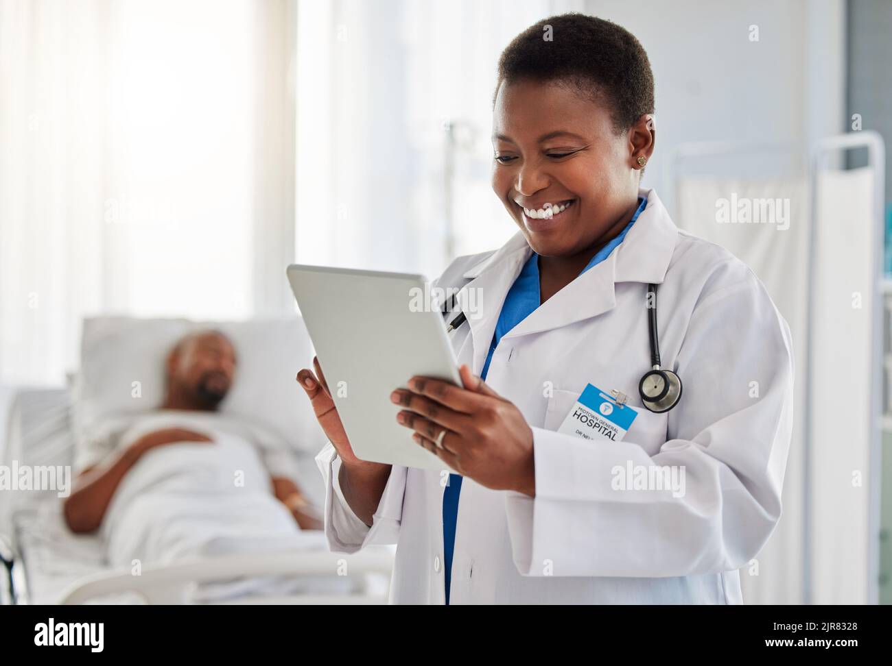 Happy news with doctor reading exciting email or test results on digital tablet, feeling positive at hospital. Young health care worker getting good Stock Photo