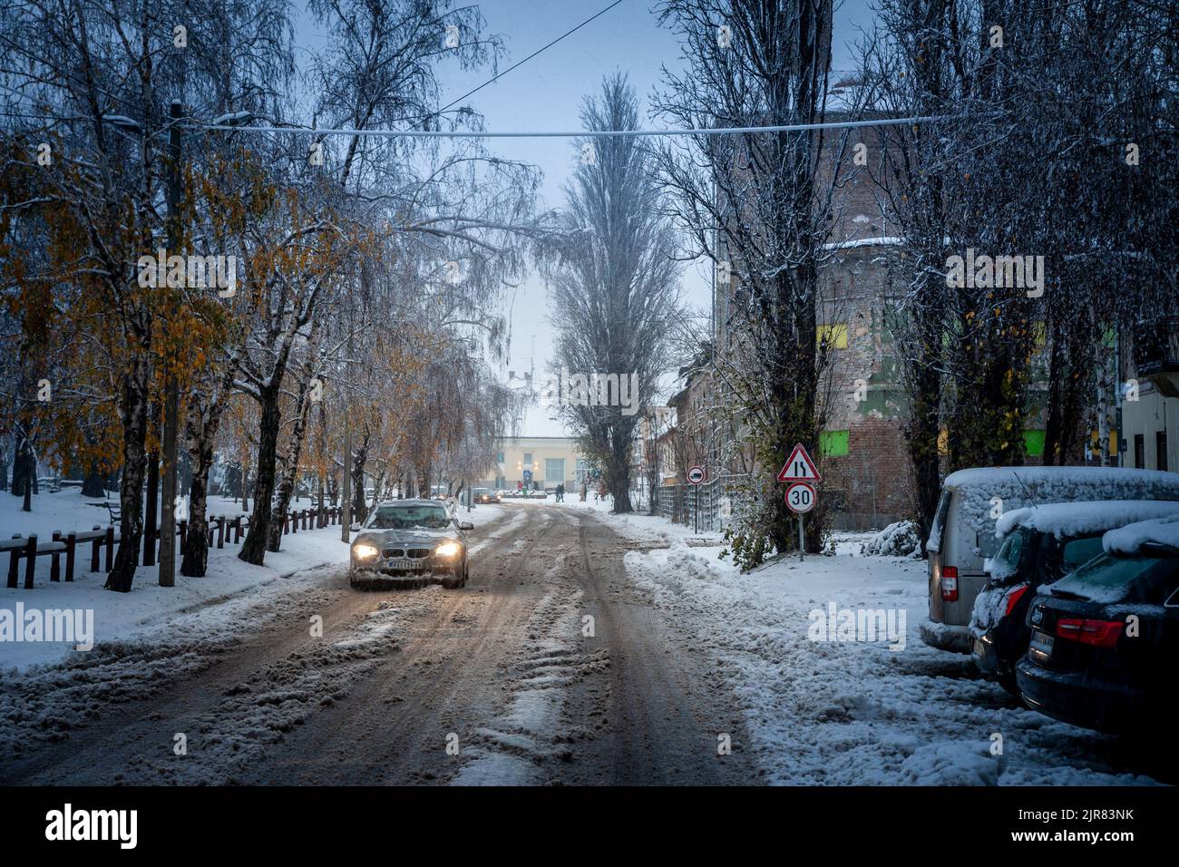 Picture of the city center of Pancevo with a cardriving during a snowstorm. Pancevo is a city and the administrative center of the South Banat Distric Stock Photo