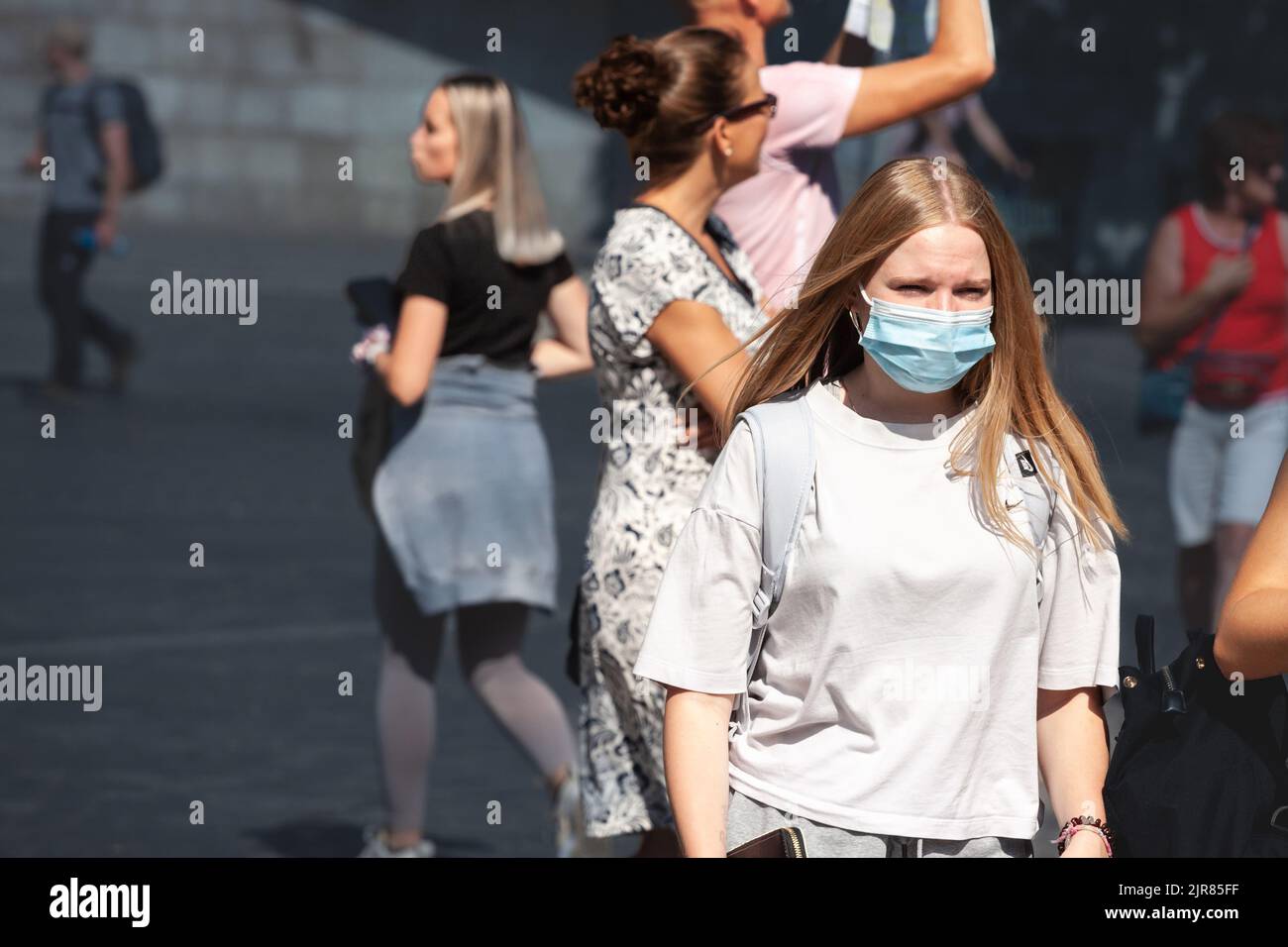 Picture of a white caucasian young woman in Ljubljana, capital city of Slovenia while wearing a respiratory face mask during the coronavirus health cr Stock Photo