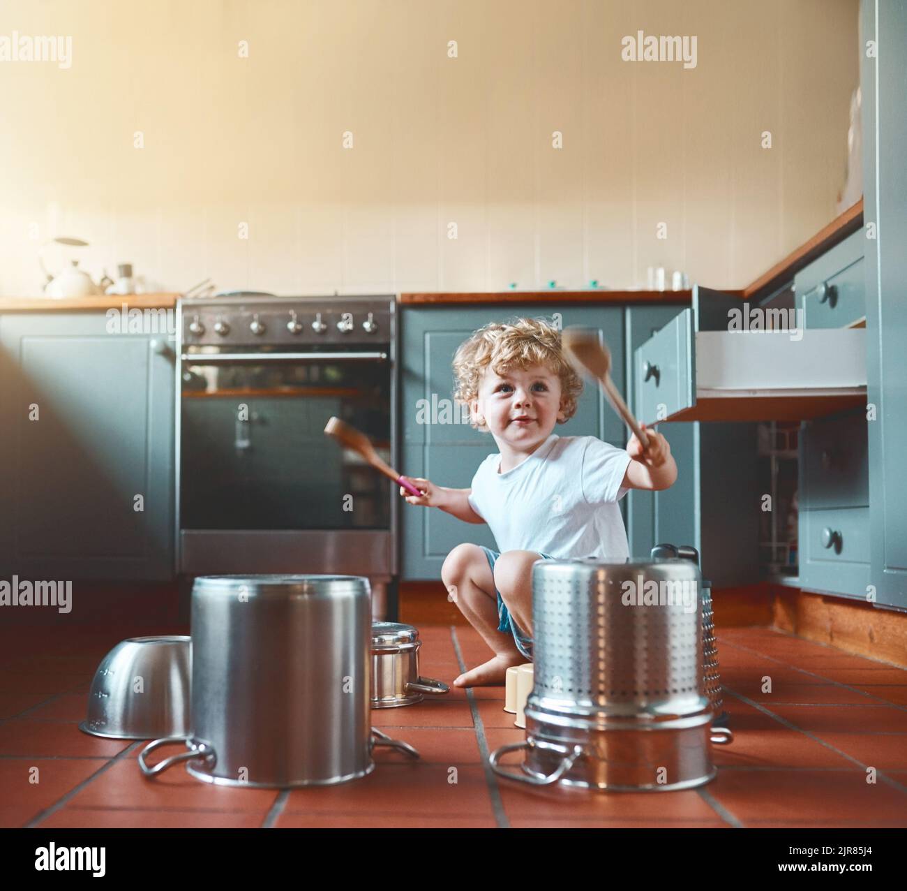 He wants to be a drummer when he grows up. Portrait of an adorable little boy playing with pots in the kitchen. Stock Photo