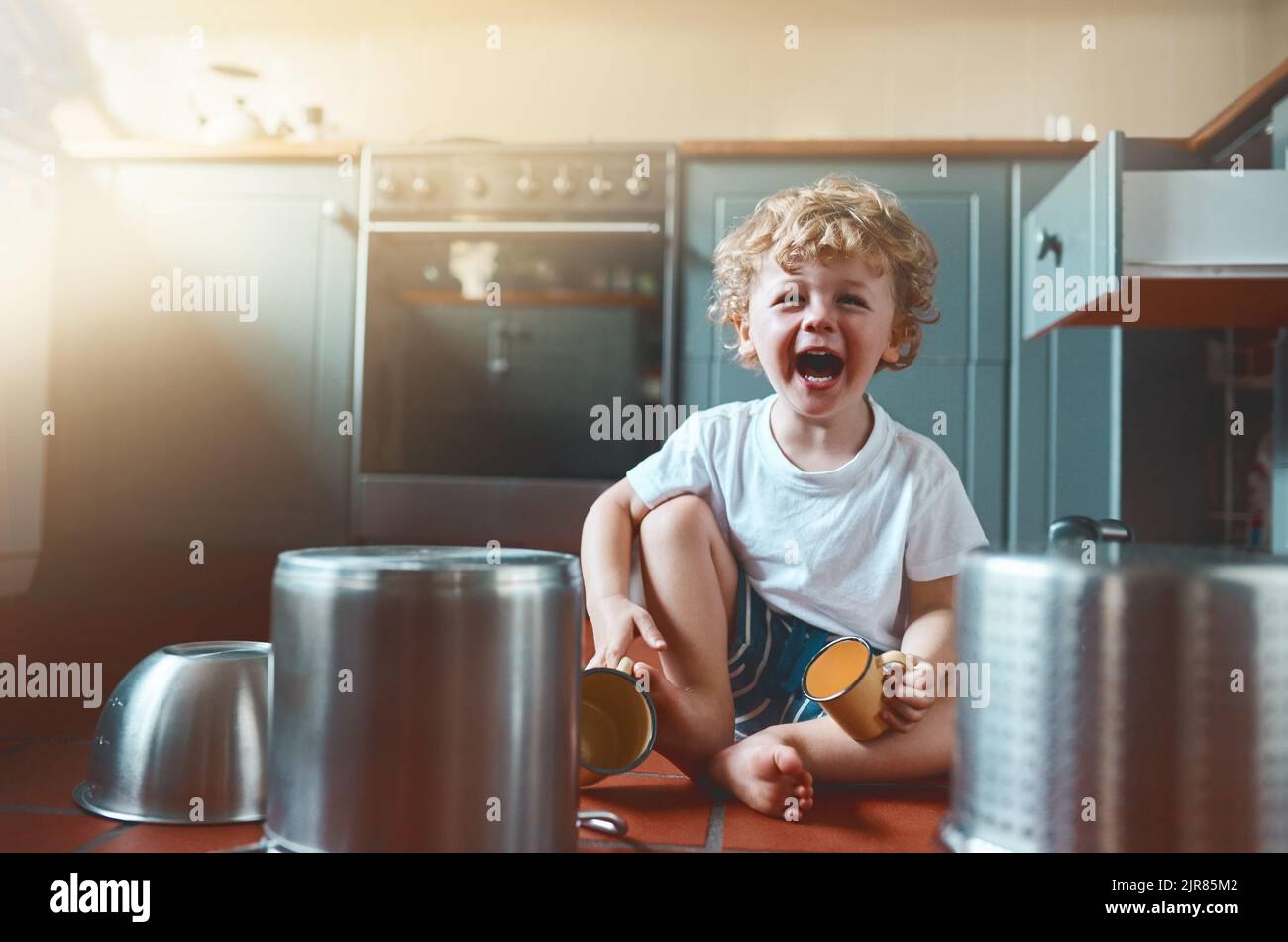 Today he imagined to be a drummer. Portrait of an adorable little boy playing with pots in the kitchen. Stock Photo