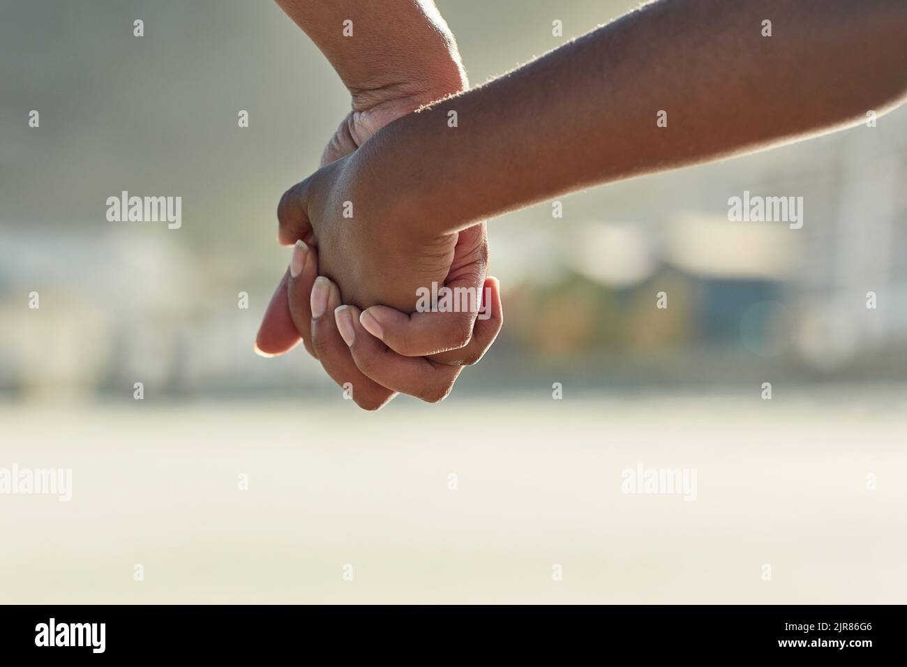 Hand in hand. Closeup shot of an adult holding a childs hand outside. Stock Photo