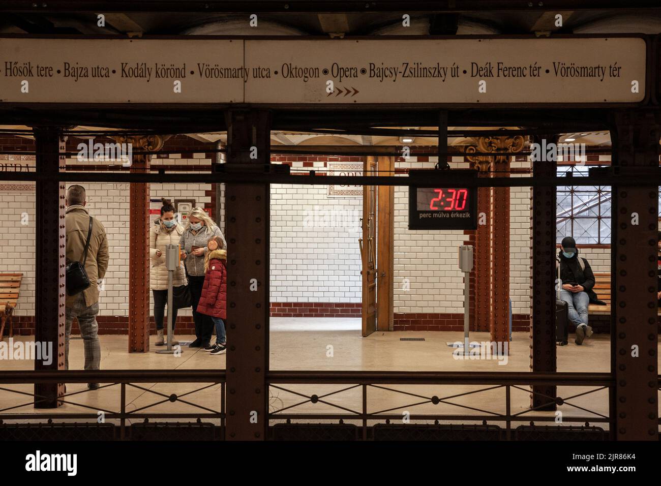 Picture of people waiting for a metro in Budapest, on line 1, wearing a face mask. The Budapest Metro (Hungarian: Budapesti metró) is the rapid transi Stock Photo