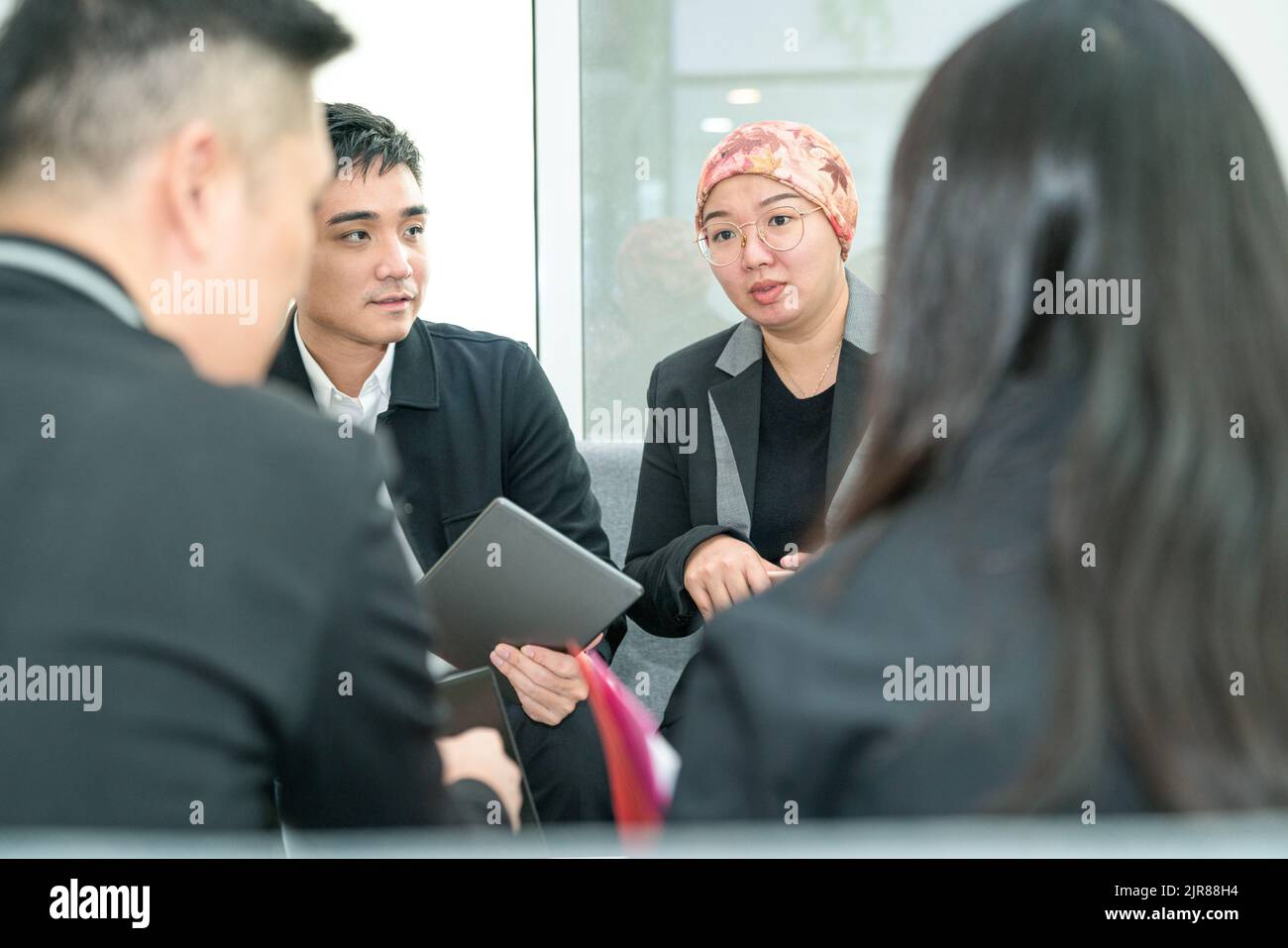 Business office colleagues having a meeting while sitting on the couch. Stock Photo