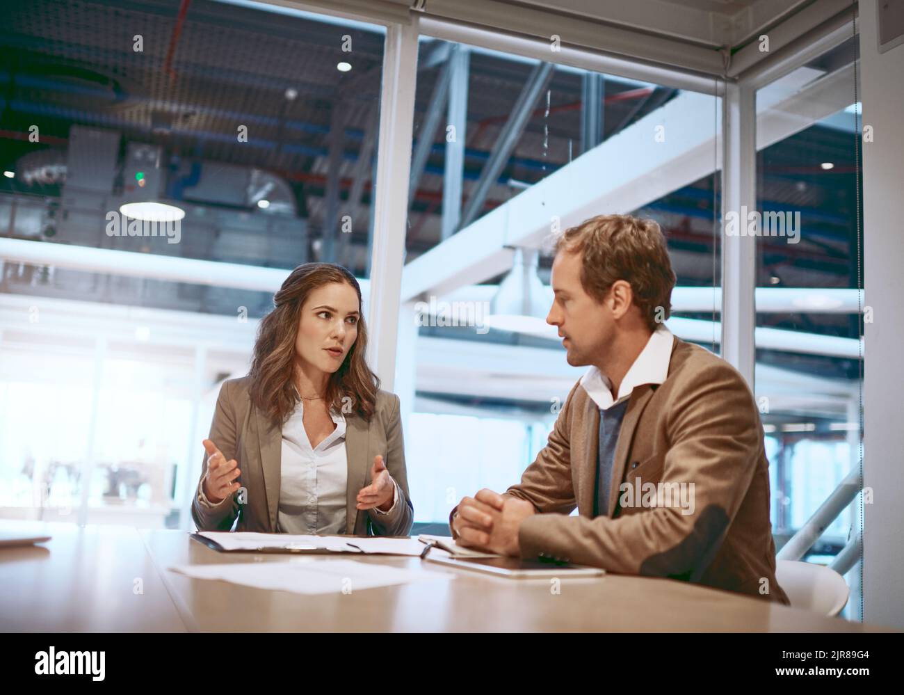 Success is a serious business. two businesspeople working together in the boardroom. Stock Photo
