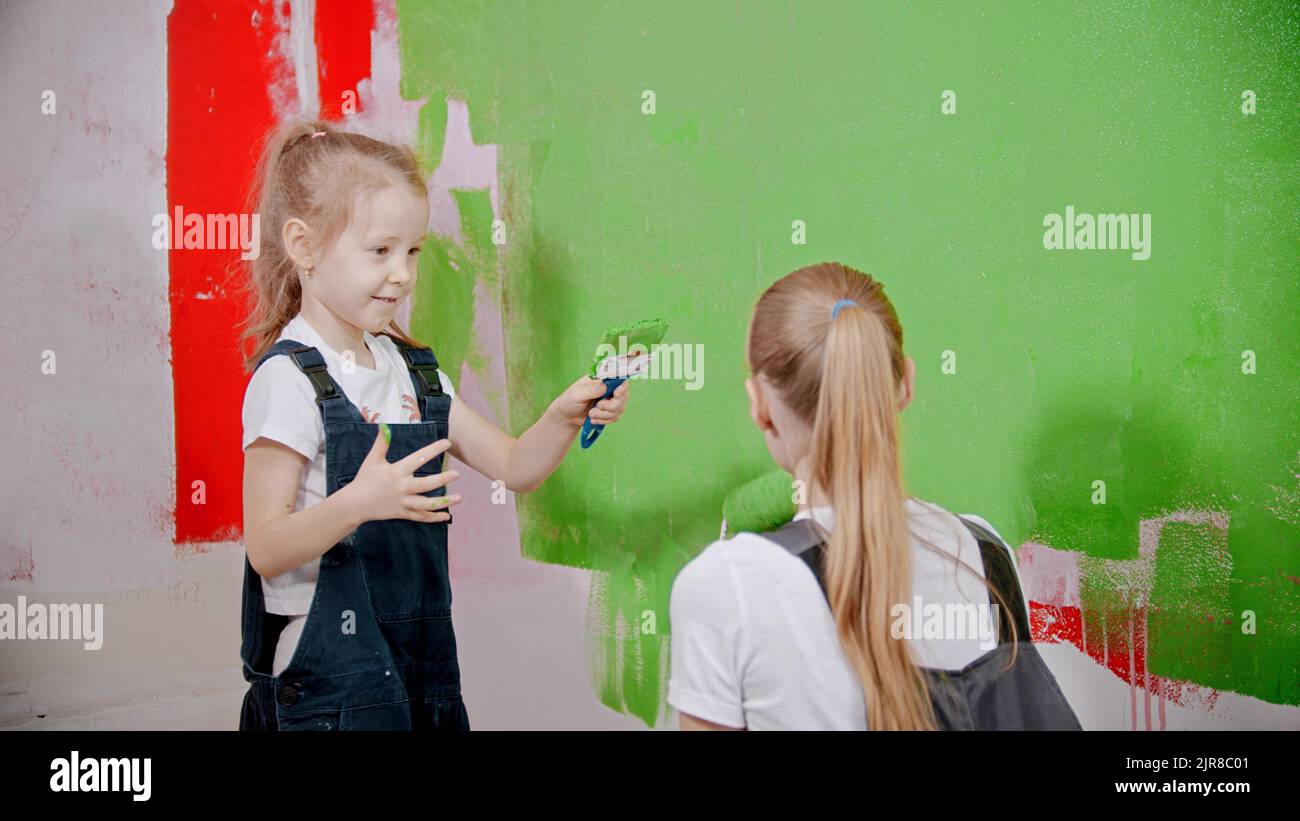 Mom and doughter having fun while painting walls in new apartments Stock Photo