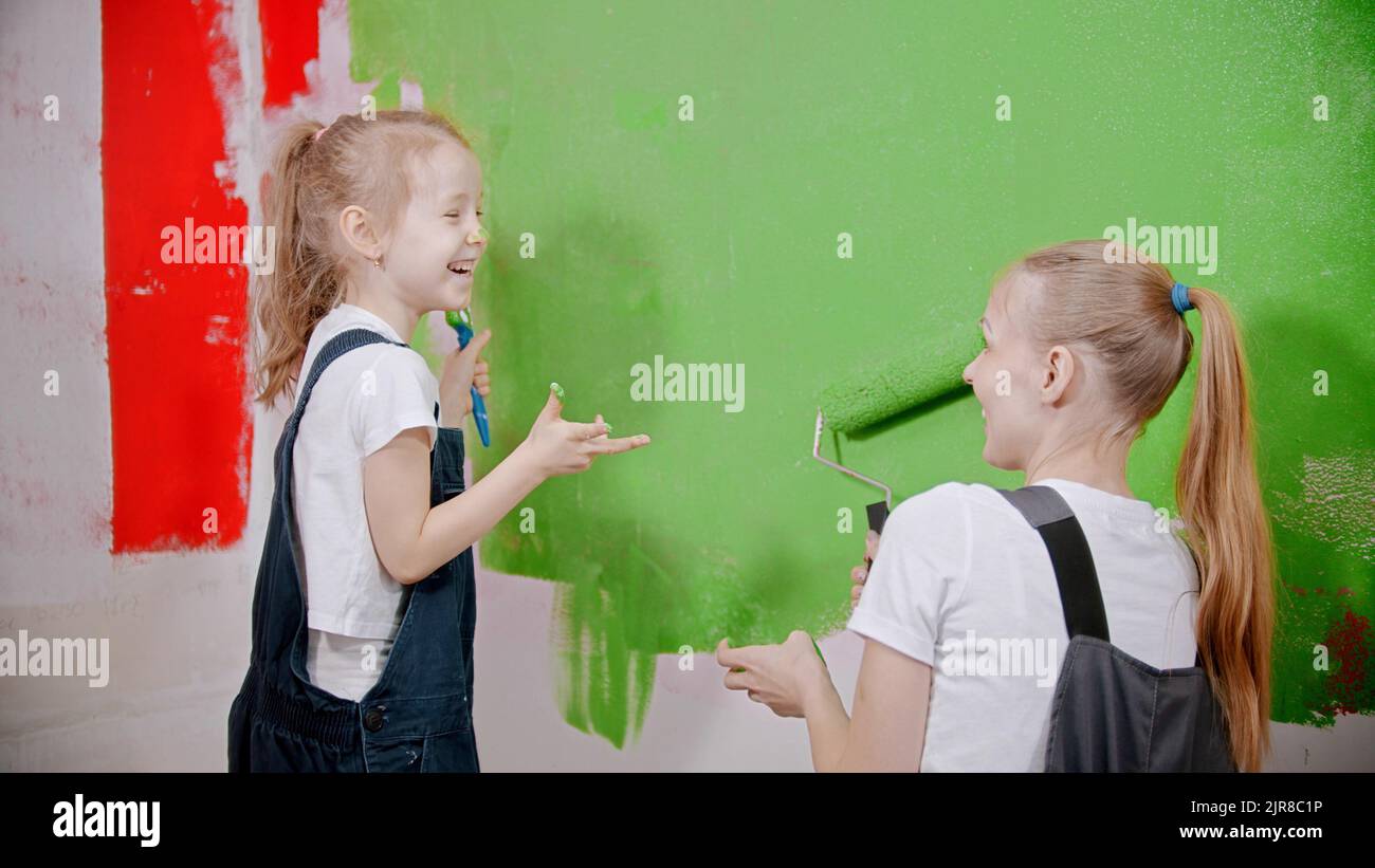 Mom and doughter having fun while painting walls Stock Photo