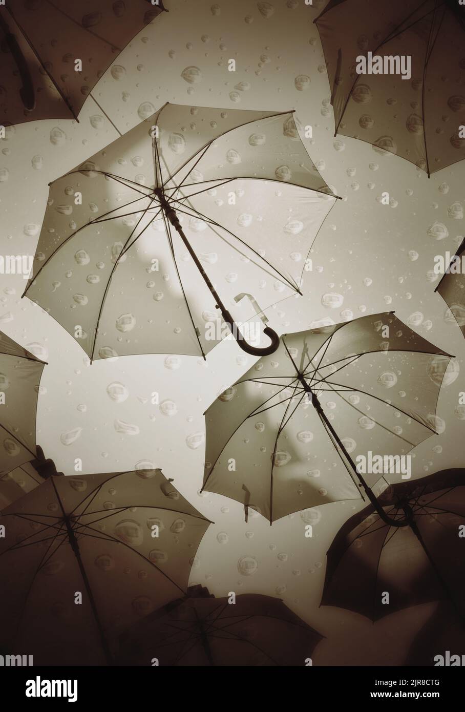 Superimposed images of raindrops and umbrellas as a representation of bad weather Stock Photo