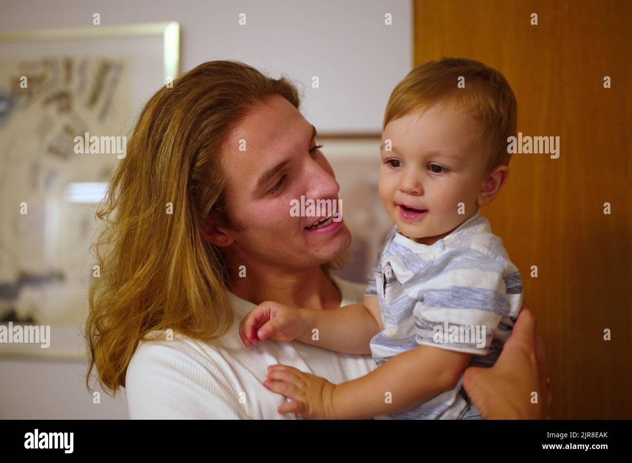 Handsome young man holding his little nephew Stock Photo