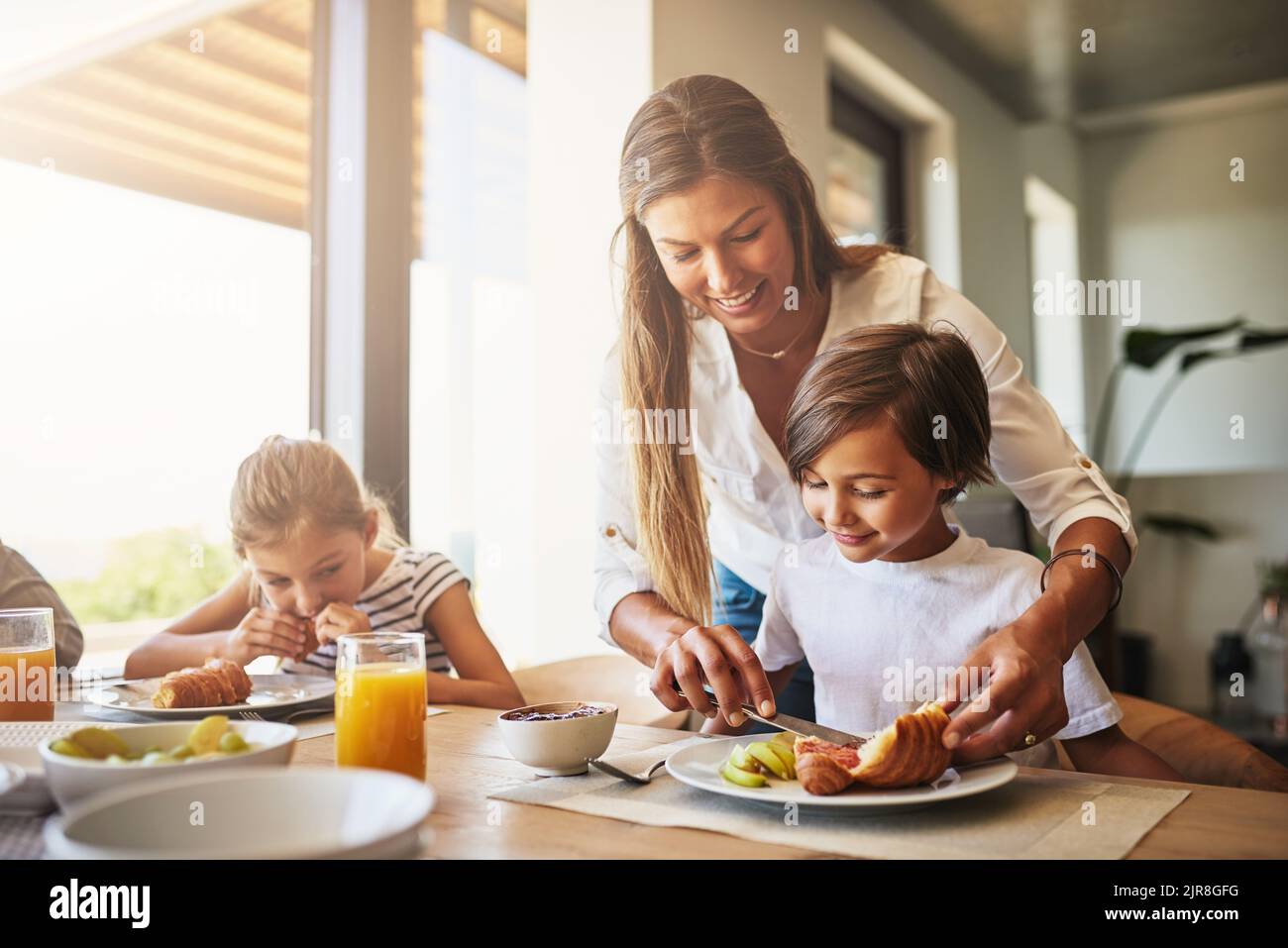 Getting the day going with a good breakfast. a mother having breakfast with her children at home. Stock Photo