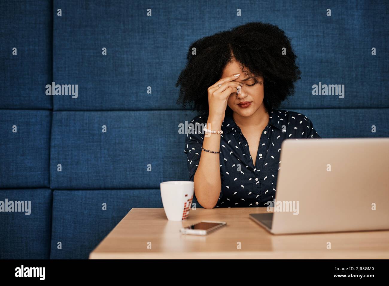How am I going to get this all done. a young female designer looking stressed while trying to work on her laptop at the office. Stock Photo