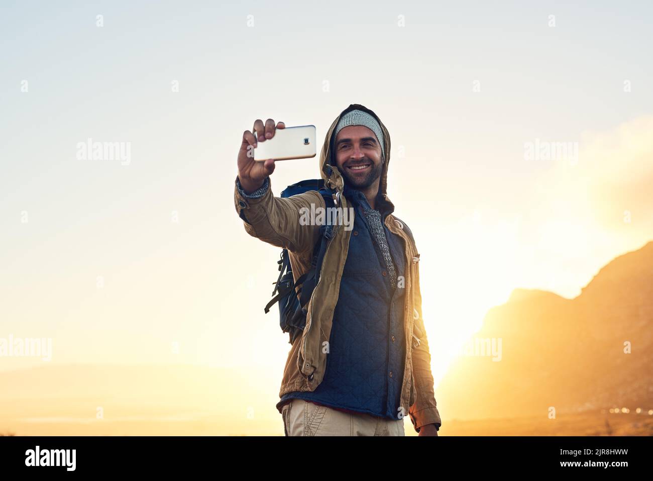 Here is proof I finished the hike. a handsome hiker on top of a mountain taking a selfie. Stock Photo