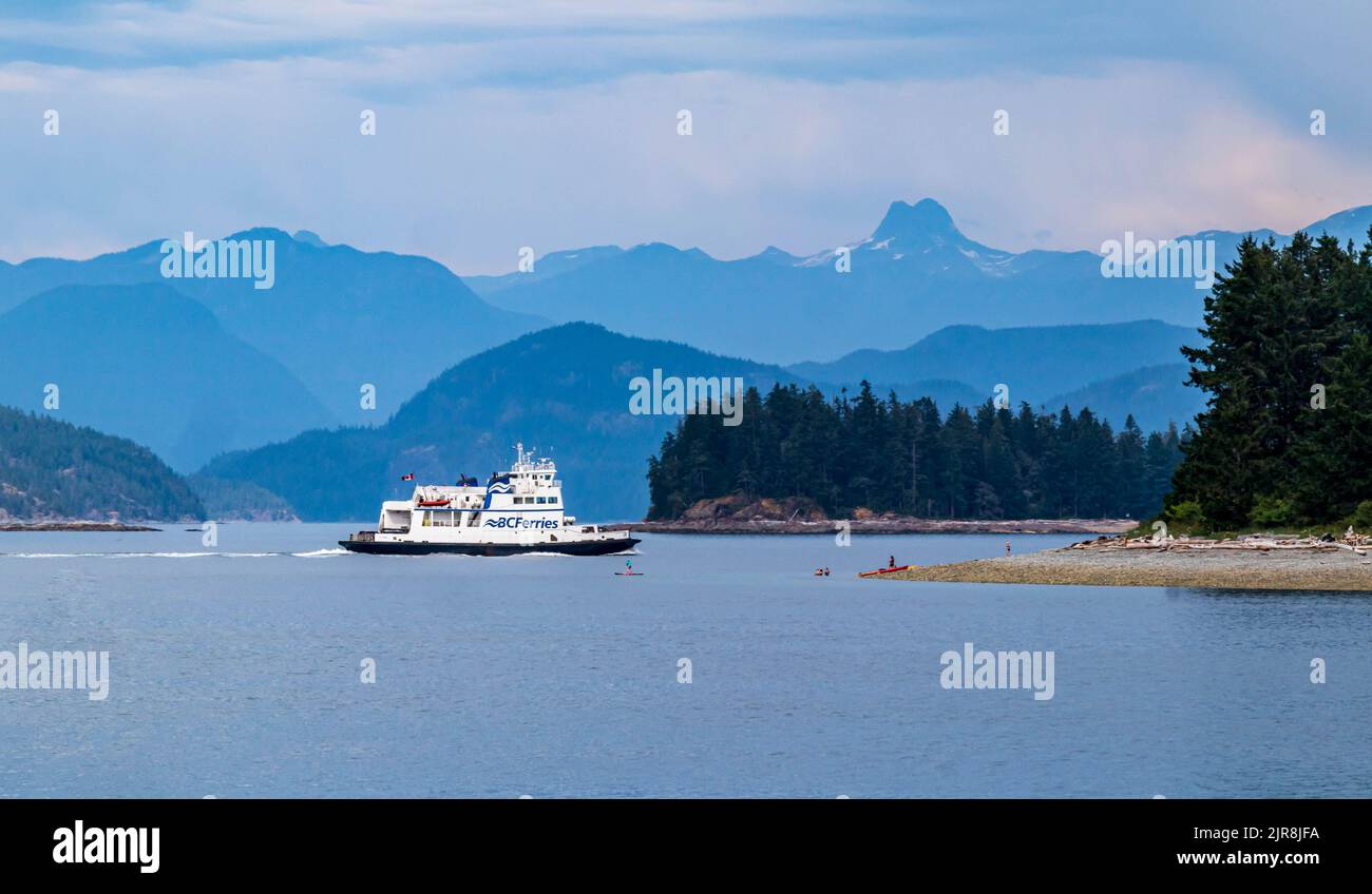 Small B.C. Ferry leaving Heriot Bay on Quadra Island, heading for Whaletown on Cortez Island.  The Discovery Islands and mainland mountains. Stock Photo