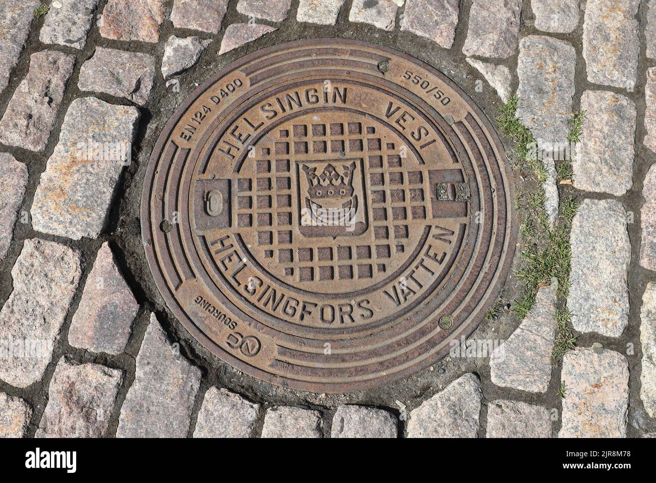 Helsinki, Finland - August 20, 2022: High angle view of a water pipe manhole with Helsinki city coat of arms. Stock Photo