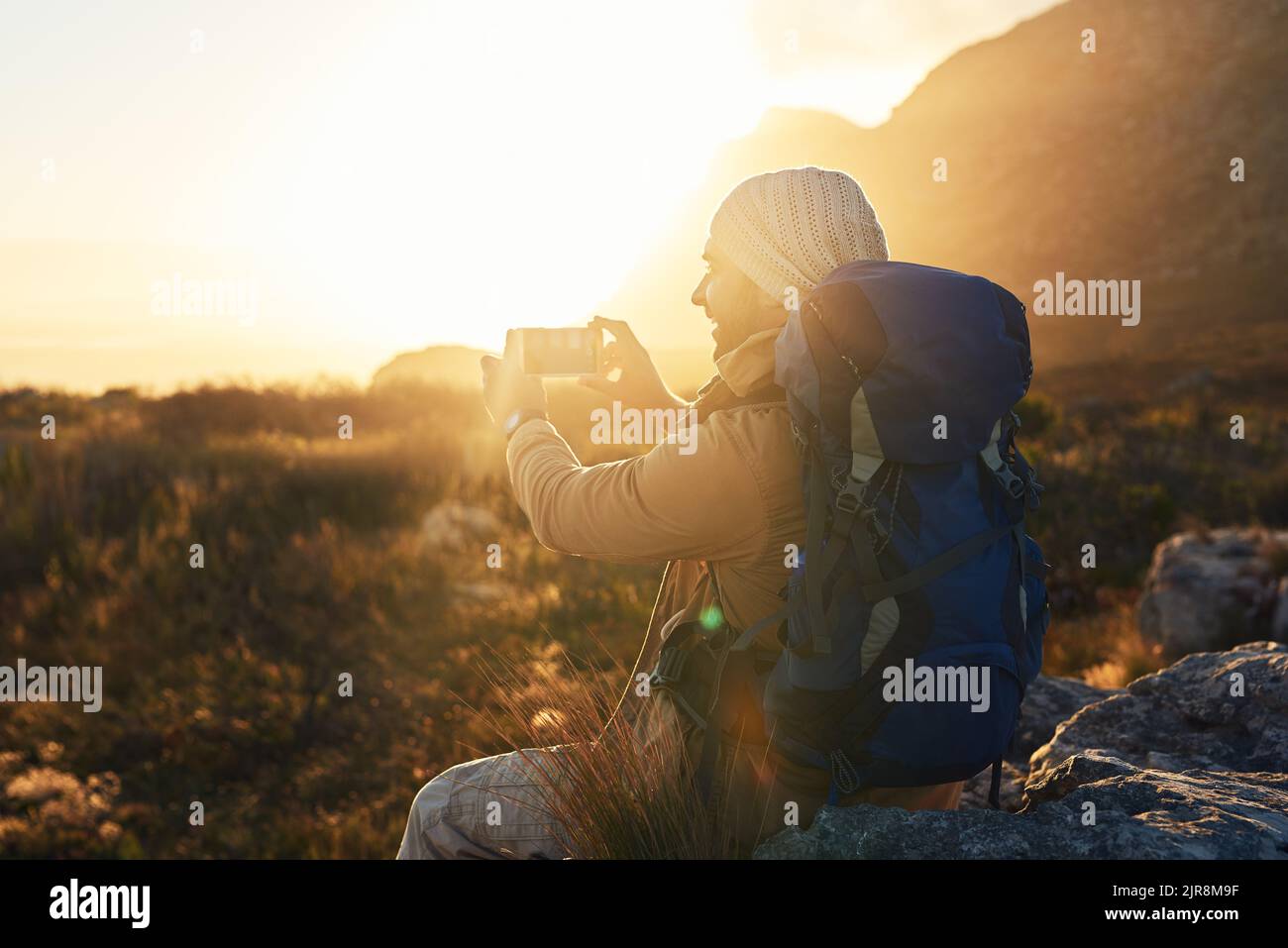 The perfect morning to capture this view. a hiker on top of a mountain capturing pictures of the view. Stock Photo