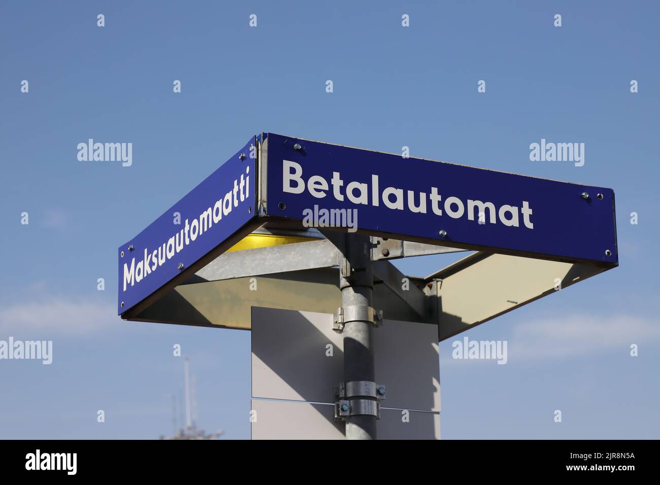 Bilinguial Finnish and Swedish sign above a pay and display machine at the car parking area. Stock Photo