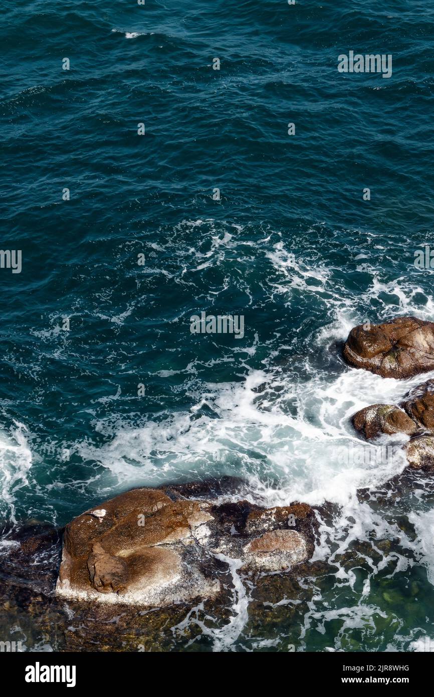 rocks in the sea. waves crashing the shore. water and stone texture. summer nature background Stock Photo
