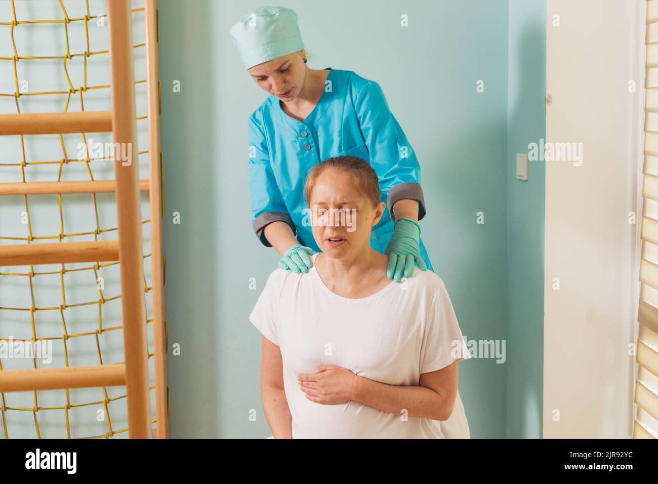 Woman gives birth at hospital, have a contraction on fitball. Nurse