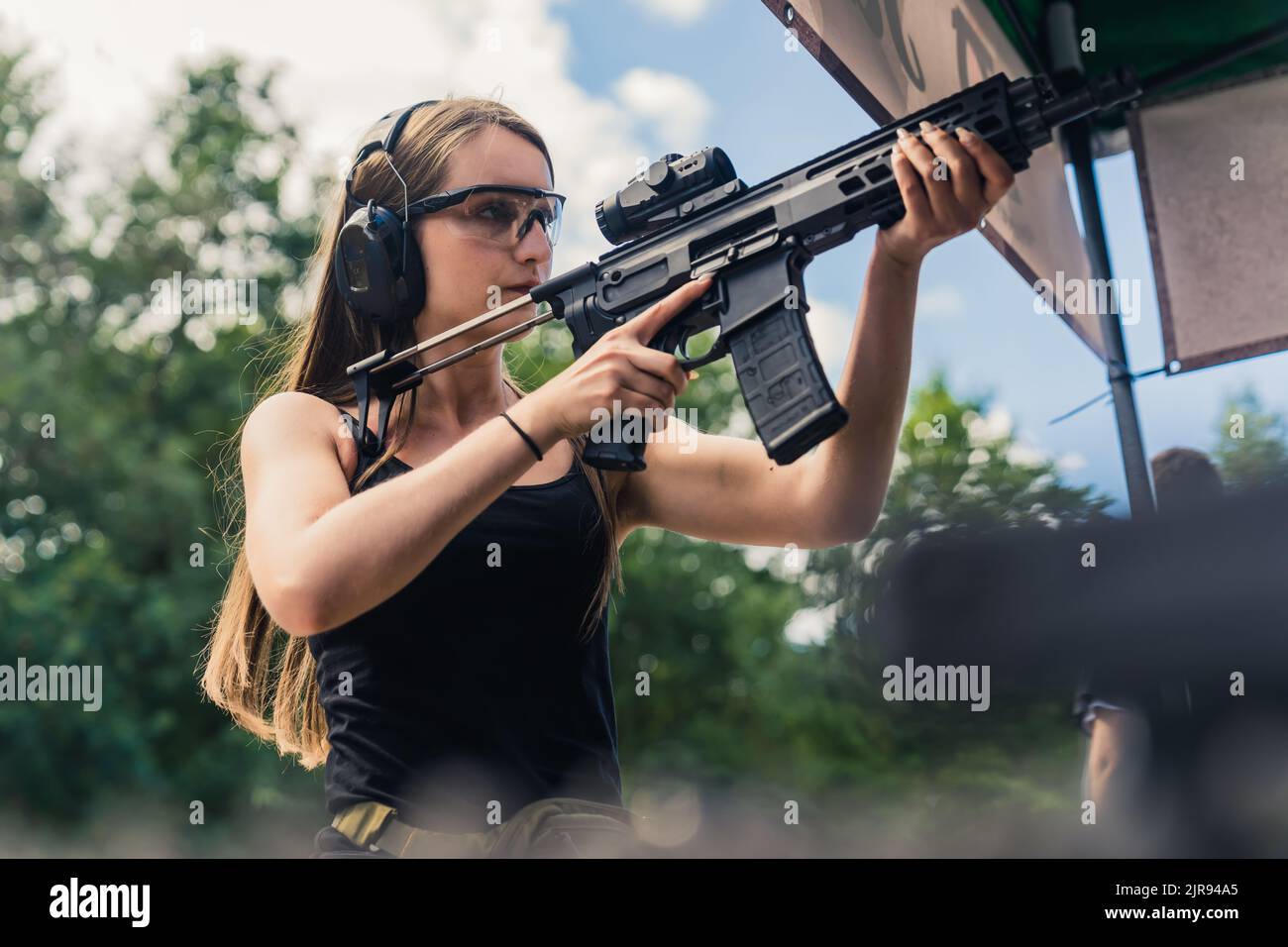 Strong powerful confident long-haired caucasian woman in a black tank ...