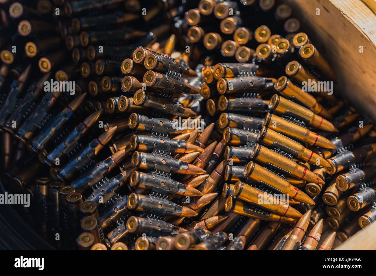 Closeup shot of shiny golden rifle bullet tapes for machine gun stored in a wooden box. Ammunition concept. Shooting range. High quality photo Stock Photo