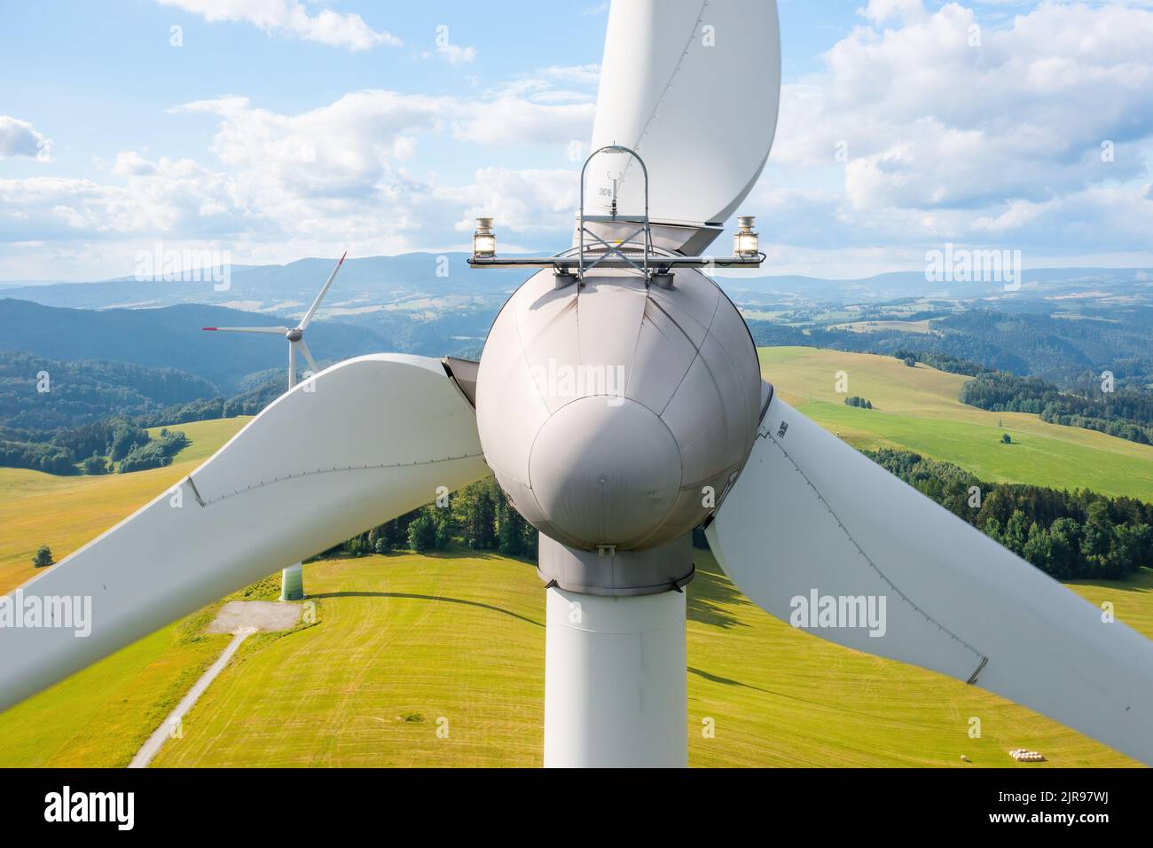 Close up a propeller of the windmill in the yellow field with mountains