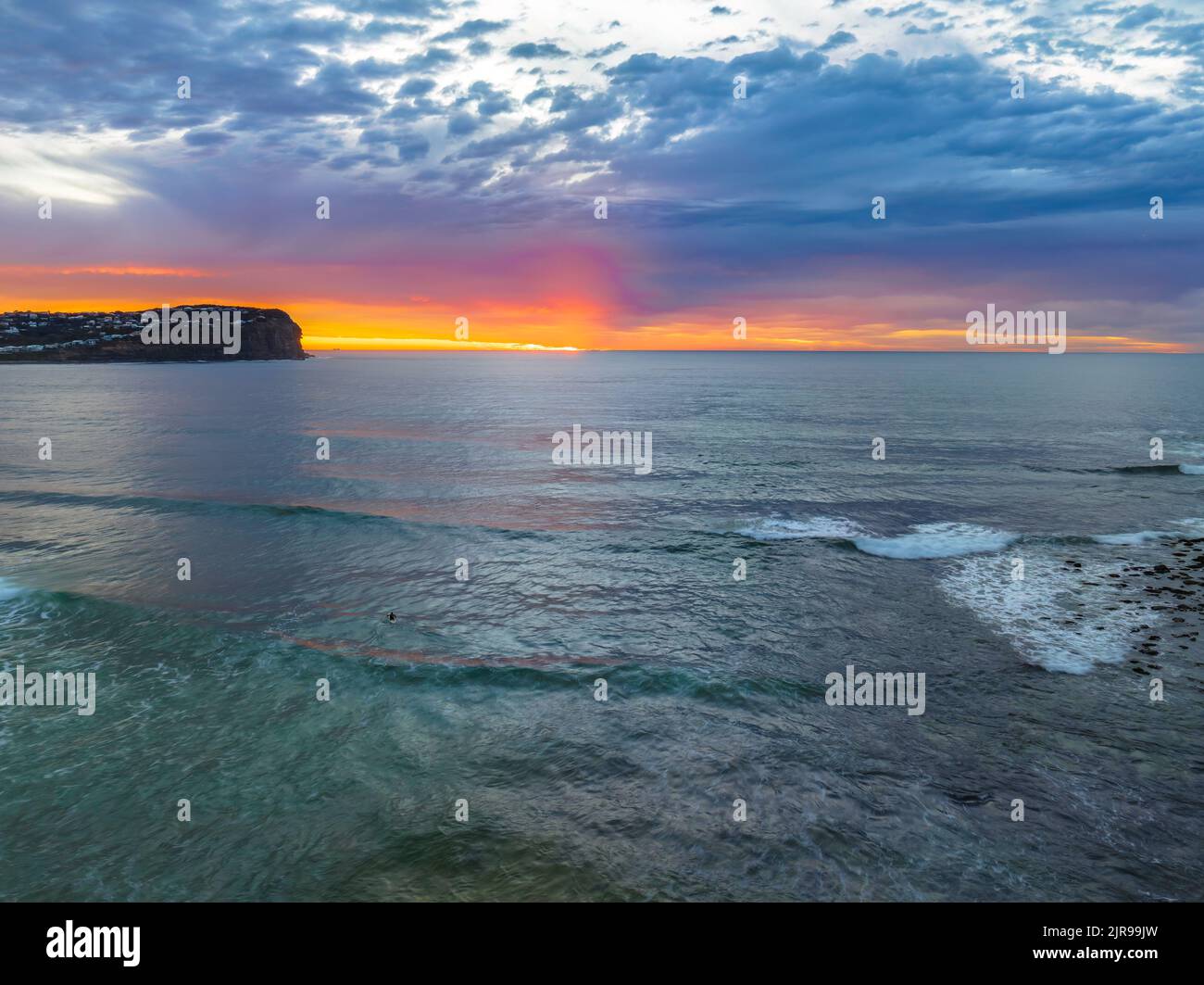 Aerial sunrise with medium and high cloud filled sky with small waves at  Macmasters Beach on the Central Coast, NSW, Australia. Stock Photo