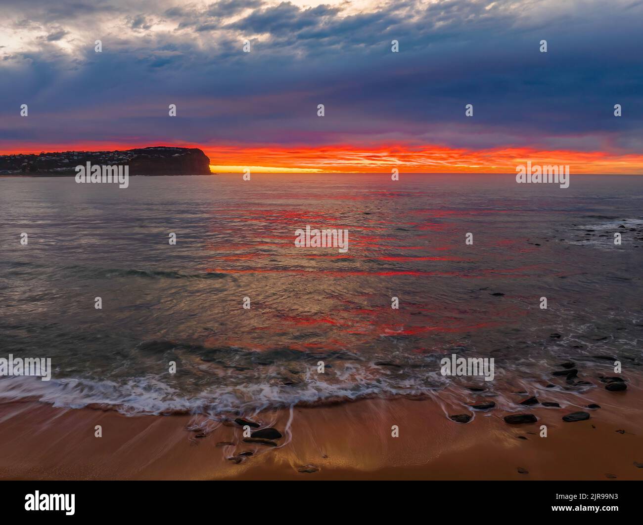 Aerial sunrise with medium and high cloud filled sky with small waves at  Macmasters Beach on the Central Coast, NSW, Australia. Stock Photo
