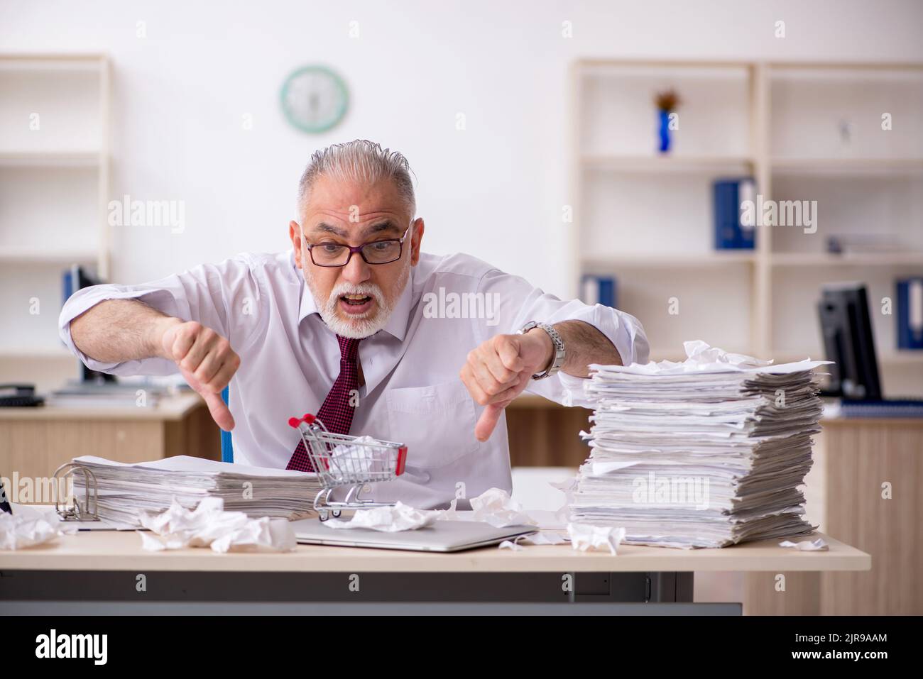 Old employee unhappy with excessive work in the office Stock Photo - Alamy