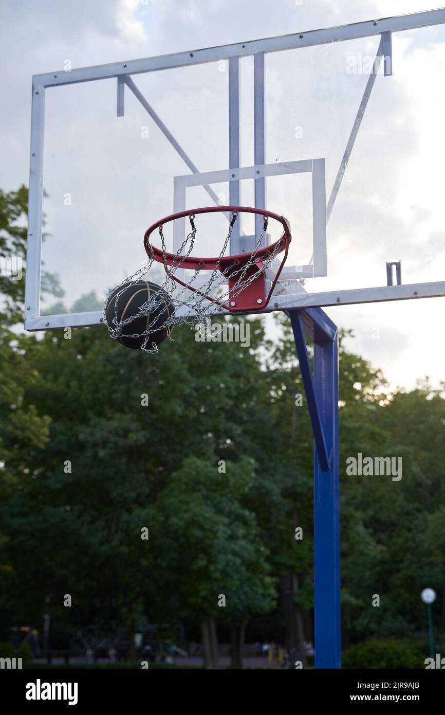 Street basketball ball falling into the hoop. Urban youth game. Concept