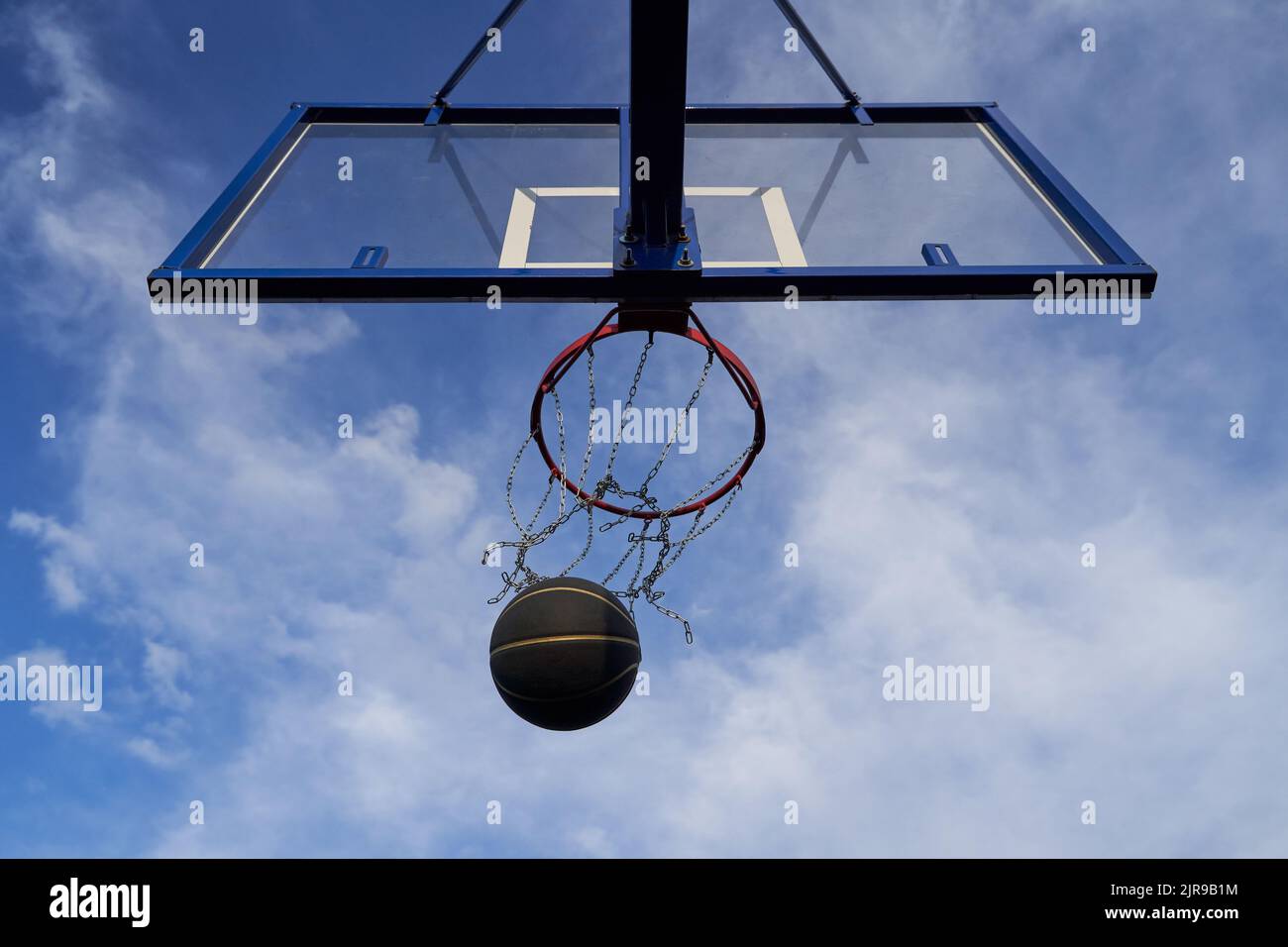Street basketball ball falling into the hoop. Concept of success