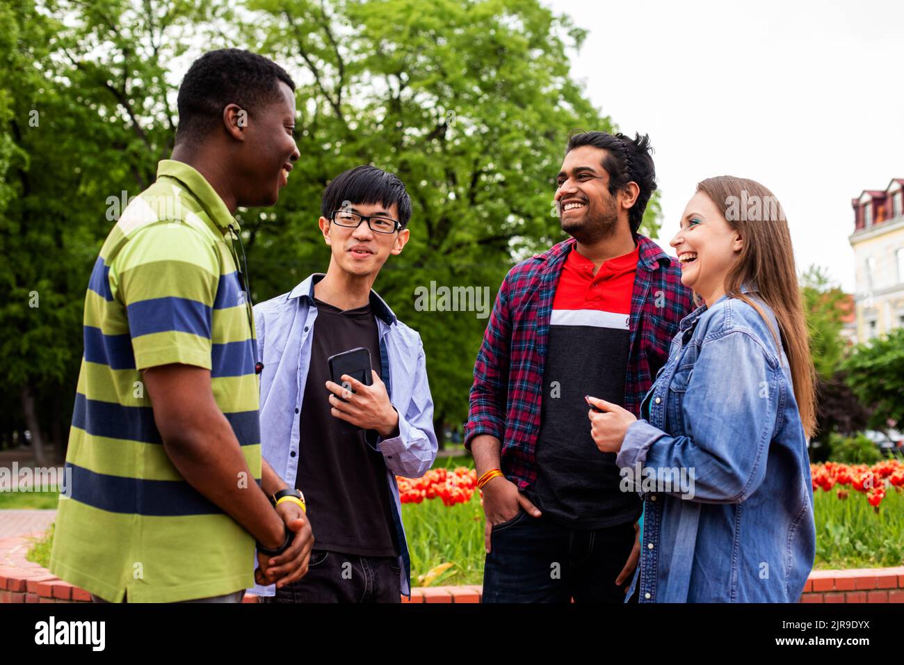 Outdoor communication between joyful multiracial college students Stock Photo