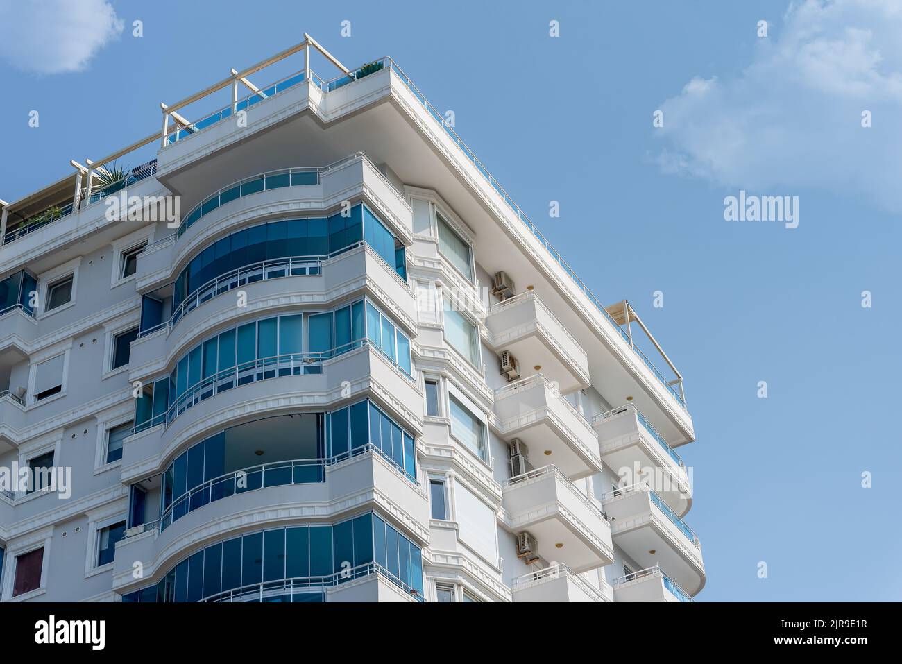 The facade of a white residential building with glazed balconies ...