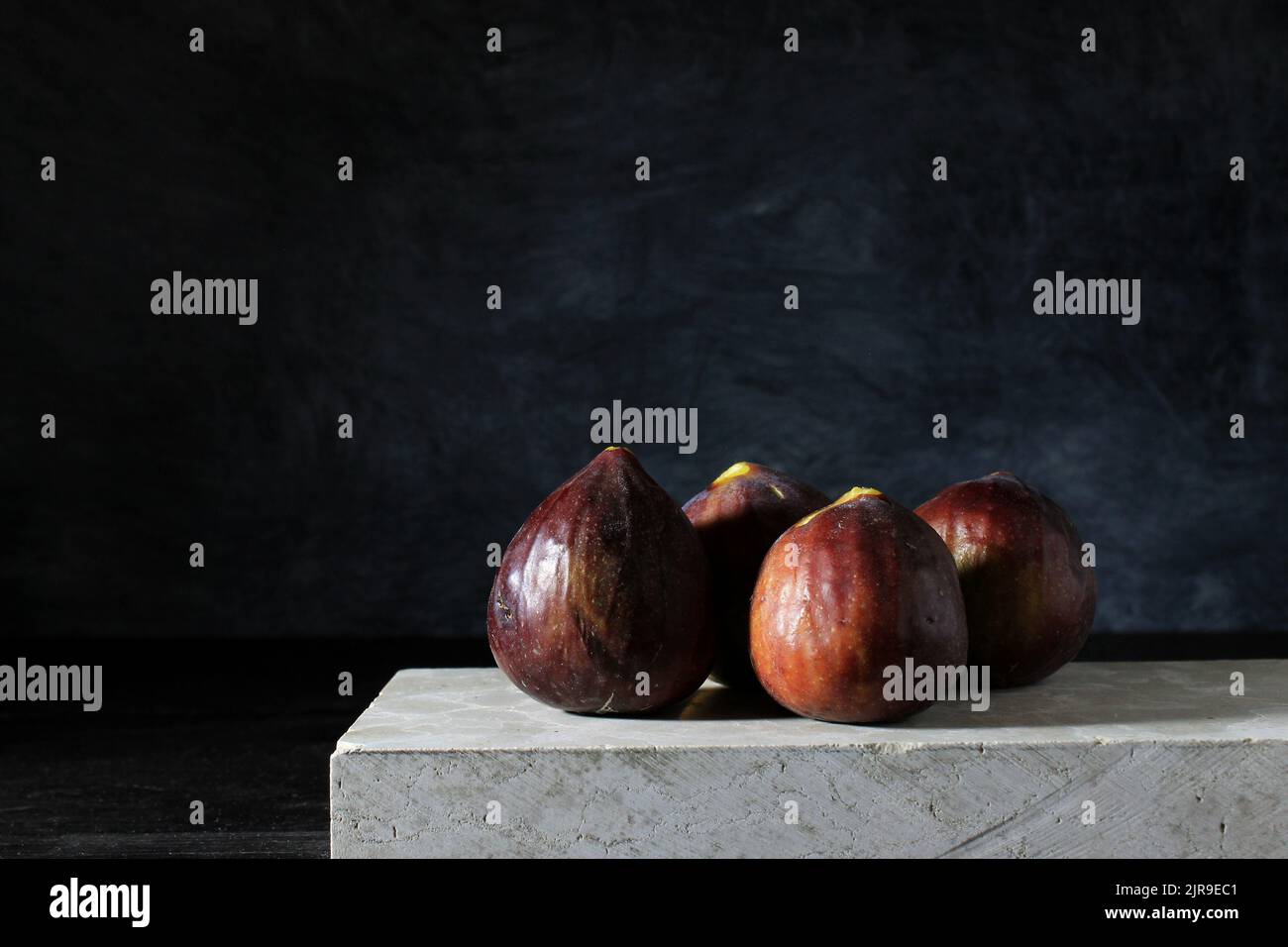 The fresh ripe figs on white marble against black background Stock ...
