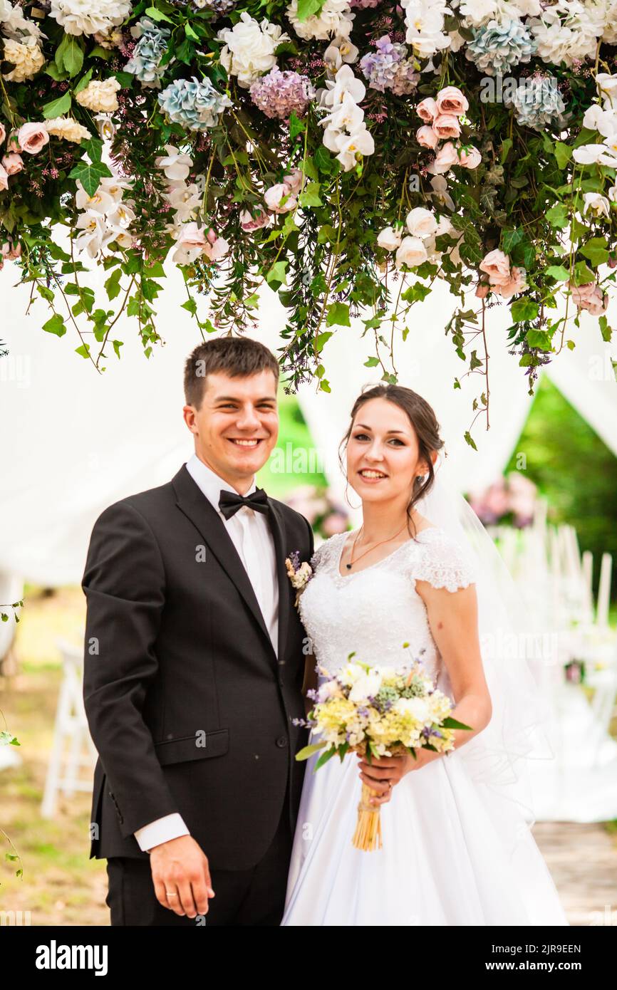 Wedding couple under the flower arch at the wedding ceremony Stock Photo