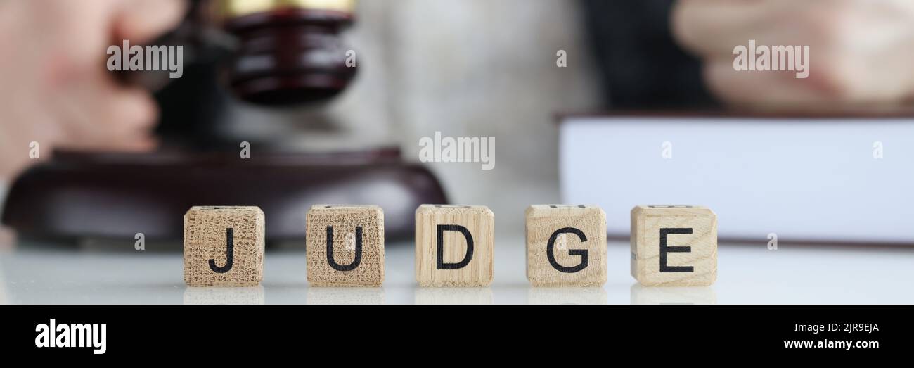 Male judge in courtroom hits with gavel and clenches fist Stock Photo