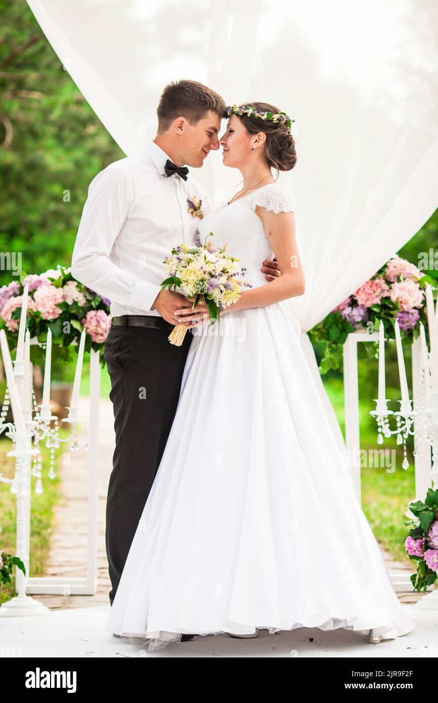 Wedding couple under the flower arch at the wedding ceremony Stock