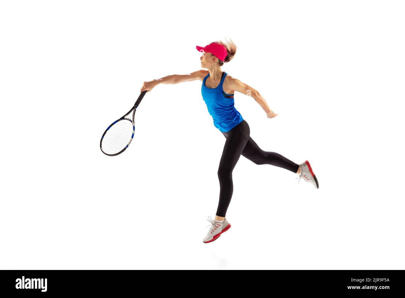 Young sportive woman, tennis player playing tennis isolated on white background. Healthy lifestyle, fitness, sport, exercise concept. Stock Photo